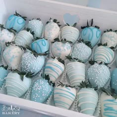 blue and white chocolate covered strawberries in a box