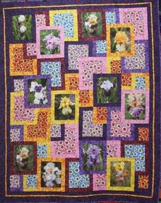 a quilt made with squares and flowers in the center is purple, pink, yellow and orange