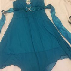 This Is A Formal Or Evening Dress. Its A Turquoise Color With Rhinestones. Its Is Satin And Chiffon. It Has Built In Bra Cups And Has Dress Lining. It Has Wide Shoulder Straps, Comes Below The Knee With A Asymmetrical Hem Line And Has A Satin Bow In The Back. This Has Never Been Worn. Elegant Turquoise Mini Dress, Thrift Clothes, Mermaid Core, Dress Lining, Hoco Dress, Thrifted Outfits, Teal Dress, Dress Inspo, Fashion 2024