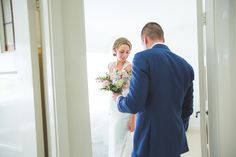 a bride and groom are looking at each other in the mirror while they stand next to each other