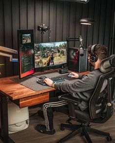 a man sitting in front of a computer with headphones on and playing video games