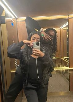 two people taking a selfie in the mirror