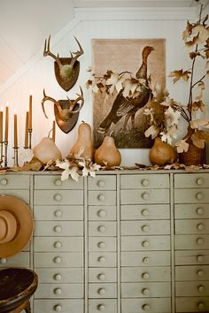 an old dresser is decorated with deer heads and other items