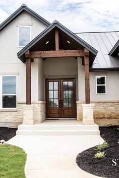 the front entrance to a home with stone and wood accents