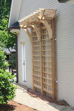 a wooden trellis on the side of a house