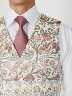 This six-button single-breasted waistcoat is cut with a traditional v-neck. Made from a soft silk/wool jacquard featuring stunning multi-coloured birds and botanicals on an ivory background, it is a statement summer garment! Featuring mother-of-pearl buttons, two welt pockets to the front, and an ivory paisley lining with an adjustable strap. Garden Party Wedding Outfit Guest Man, Floral Vest Groom, Indian Waistcoat, Luxury Traditional Embroidered Vest, Patterned Waistcoat, Embroidered Waistcoat For Men, Fae Wedding, Regency Mens Waistcoat, Waistcoat Design