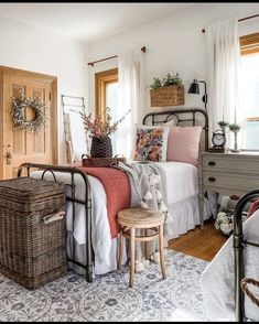 a bed room with a neatly made bed and baskets on the nightstands next to it