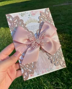 a person holding up a card with a pink bow on it