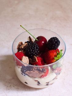 a glass bowl filled with fruit and ice cream