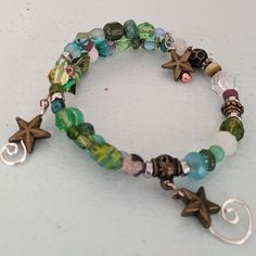 This Is A Fun Bracelet With Various Glass Beads In Shades Of Blue And Green With Handmade Coil Spirals Hanging From The Ends. Blue Bracelets Aesthetic, Unique Bead Bracelets, Beaded Bracelets Colorful, Green And Brown Bracelets, Grudge Bracelets, Fairy Grunge Bracelets, Grunge Bracelet Ideas, Bracelet Ideas Grunge, Bead Bracelet Inspiration