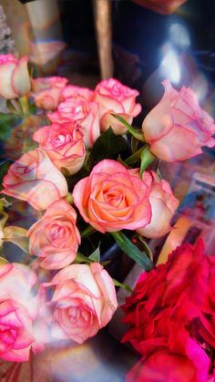 a bunch of pink roses sitting on top of a table