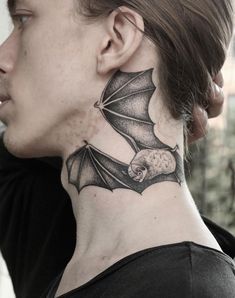 a woman with a bat tattoo on her neck