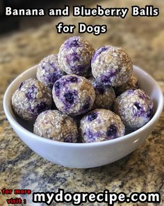 a white bowl filled with blueberry balls on top of a counter