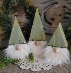 three little gnomes sitting on top of a doily