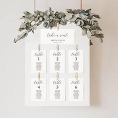 a seating chart with eucalyptus leaves and clothes pins