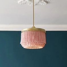 a pink chandelier hanging from the ceiling in a room with blue walls and white trim