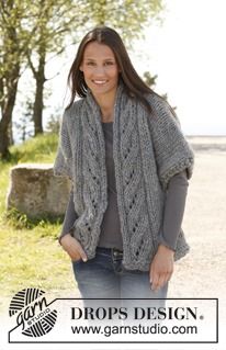 a woman standing in the middle of a road wearing a knitted shawl and smiling