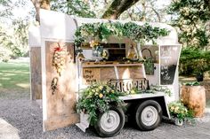 a food truck is decorated with flowers and greenery