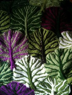 several knitted leaves are arranged together on a table