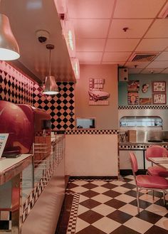 the interior of a diner with checkered flooring and pink walls, black and white tiles