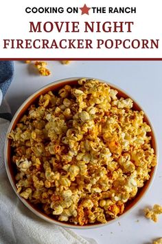 a bowl filled with popcorn sitting on top of a white table next to a napkin