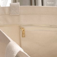 the inside of a white purse with gold zippers and an open pocket on it