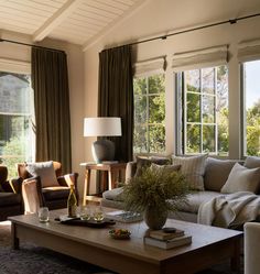 a living room with two couches and a coffee table in front of large windows