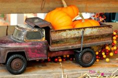 an old toy truck with pumpkins in the back