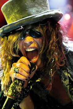 a man in a top hat and sunglasses singing into a microphone with the words dream on it