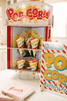 pop corn popcorn machine with various flavors on display in front of box and card board