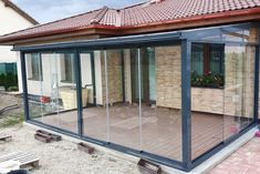 a glass enclosed patio with wooden decking and sliding doors on the side of it