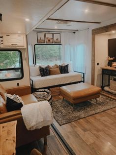 a living room filled with furniture next to a window and a tv mounted on top of a wall