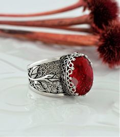 "The 925 sterling silver filigree cocktail ring features a lab created ruby quartz gemstone set in an oxidized sterling silver tulip pattern filigree design. The ring has a wonderful filigree pattern that goes all the way around the face of the ring. We used the finest workmanship to create this beautiful cocktail ring which makes it unique and fun to wear.         This beautifully crafted red stone sterling silver cocktail ring will make you feel special when you wear it because it looks so classy and elegant.        The lab created red ruby Gemstone is 10X14 mm, double side faceted, checkerboard oval-cut and the ring face length is 0.60\" / 15.00 mm and width is 0.45\" / 11.50 mm.          Embellish your fingers with enchanting details. Delicate and feminine, this ring features stunning Elegant Luxury Red Filigree Ring, Luxury Red Filigree Ring, Red Filigree Ring With Gemstone For Gift, Ruby Filigree Ring As Gift, Gift Filigree Ring With Stone Setting, Handmade Elegant Ruby Ring Gift, Elegant Handmade Ruby Ring For Gift, Silver Filigree Ring With Stone Setting For Gift, Sterling Silver Filigree Ring With Gemstone For Gift