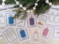 several cards with candles and christmas ornaments on the table in front of a garlanded tree