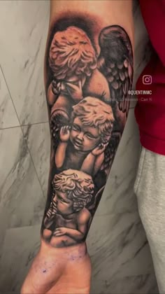 an arm with some tattoos on it and two angels in the middle, one is holding a