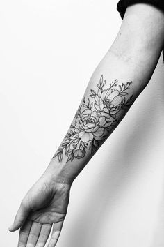 a woman's arm with a flower tattoo on the left hand and a black and white background