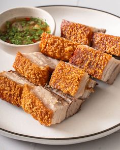 slices of meat on a plate with dipping sauce