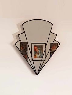 a mirror that is on the wall with some pictures hanging from it's sides