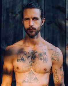 a shirtless man with tattoos on his chest