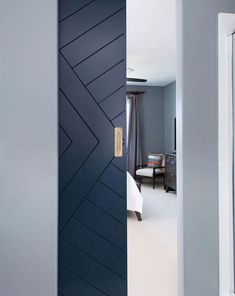 an open door leading to a bedroom with blue walls and white carpeted flooring