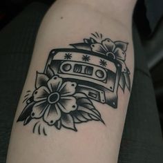 a black and white photo of a tattoo with a cassette on it's arm