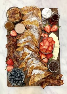 a platter filled with french toast, strawberries and other foods