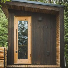 a small wooden cabin in the woods with its door open and windows opened to let in natural light