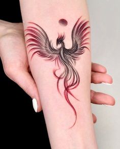 a woman's arm with a bird tattoo on it