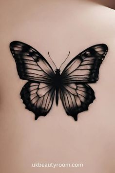 a black and white butterfly tattoo on the back of a woman's upper body