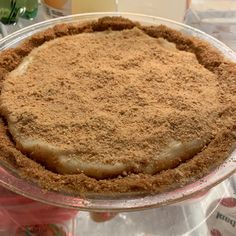 a pie sitting on top of a glass plate covered in crumbly toppings