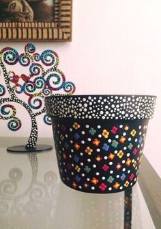 a black and white basket sitting on top of a table next to a small tree