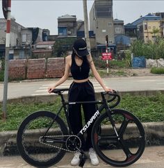 a woman standing next to her bike on the street