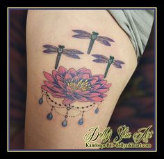 a woman's thigh with dragonflies on it and a pink flower in the middle