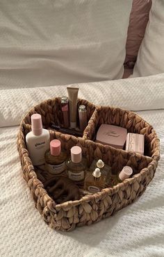 a wicker basket filled with cosmetics and personal care items on top of a bed